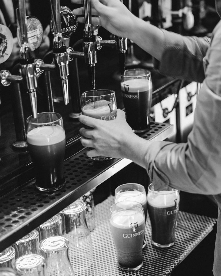 Pints of Guinness being poured at the bar.