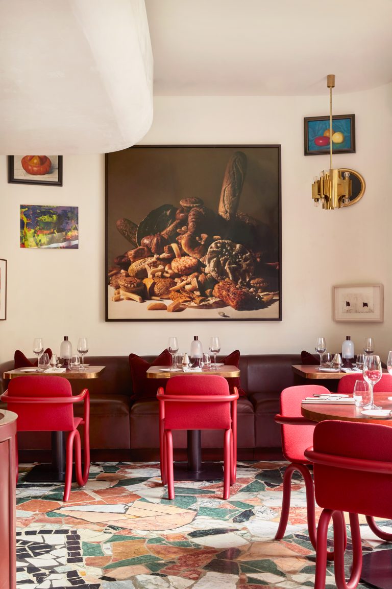 A view of Mount St. Restaurant. Red chairs are situated around tables and the walls are decorated with artworks.