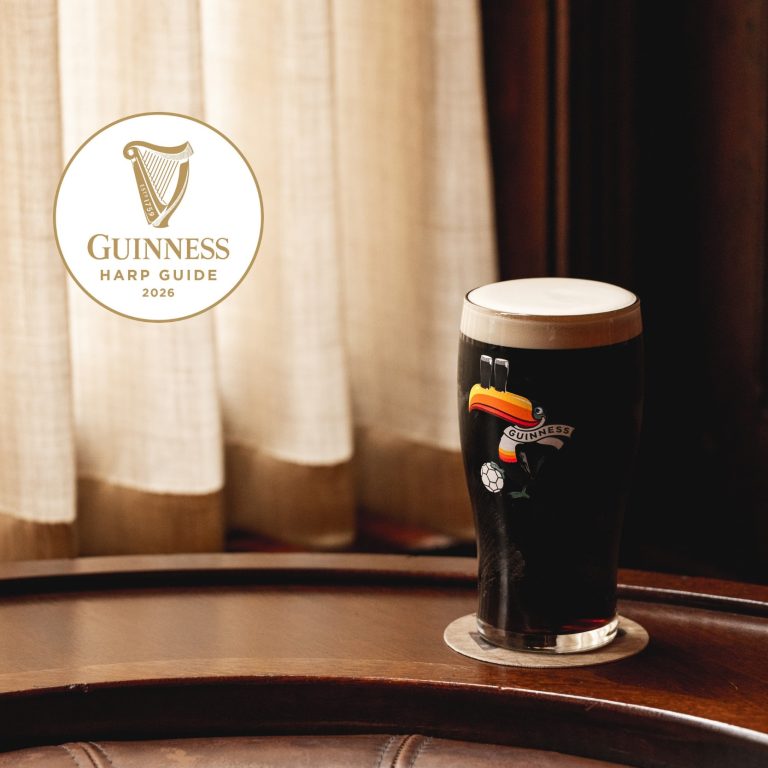 A photo of a pint of Guinness in a branded glass with a toucan on it, and the 'Guinness Harp Guide' emblem to the left